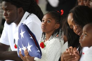 Ah'Leesya Johnson holds a folded American flag given to her during the burial service for her father U.S. Army Sgt. La David Johnson at the Memorial Gardens East cemetery on October 21, 2017 in Hollywood, Florida. (Credit: Joe Raedle/Getty Images)