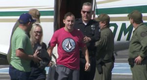 Officer Michael Gracia steps off the plan after returning to Southern California on Oct. 6, 2017. (Credit: KTLA) 