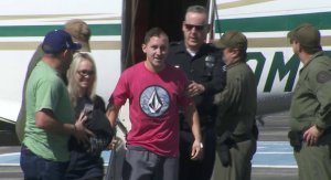 Officer Michael Gracia steps off the plan after returning to Southern California on Oct. 6, 2017. (Credit: KTLA)