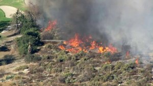 Firefighters battle a blaze near the Hansen Dam in Lake View Terrace. (Credit: KTLA)