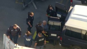 Bruce Paddock, in a wheelchair, is placed into a police van on Oct. 25, 2017. (Credit: KTLA)