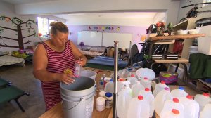 Margarita Cosme Fuentes washes dishes in the classroom serving as her temporary home in hurricane-devastated Puerto Rico in Oct. 2017. (Credit: CNN)