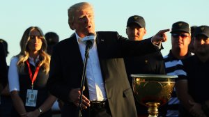 U.S. President Donald Trump presents the U.S. Team with the winning trophy after they defeat the International Team in the Presidents Cup at Liberty National Golf Club on Oct. 1, 2017, in Jersey City, New Jersey. (Credit: Elsa/Getty Images)