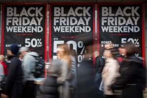 People walk past a shopfront on Oxford Street advertising 'Black Friday' discounts on November 28, 2014 in London, England. (Credit: Rob Stothard/Getty Images)