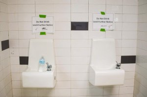 Placards posted above water fountains warn against drinking the water at Flint Northwestern High School in Flint, Michigan, May 4, 2016. (Credit: Jim Watson / AFP / Getty Images)