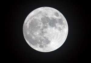In this photo from Dec. 13, 2016, clouds clear to allow a view of the final full moon of the year, a so-called 'Cold Moon', as it appears behind lights illuminating Penzance seafront in Cornwall, England. (Credit: Matt Cardy/Getty Images)