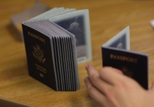 A Passport Processing employee uses a stack of blank passports to print a new one at the Miami Passport Agency on June 22, 2007. (Credit: Joe Raedle / Getty Images)