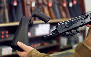 A bump stock device (left), that fits on a semi-automatic rifle to increase the firing speed, making it similar to a fully automatic rifle, is shown next to a AK-47 semi-automatic rifle (right), at a gun store in Salt Lake City, Utah. (Credit: George Frey/Getty Images)