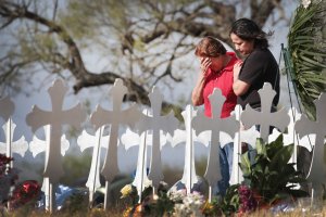 Maria Durand (left) and her daughter Lupita Alcoces visit a memorial where 26 crosses stand in a field on the edge of town to honor the victims killed at the First Baptist Church of Sutherland Springs on November 7, 2017. (Credit: Scott Olson/Getty Images)