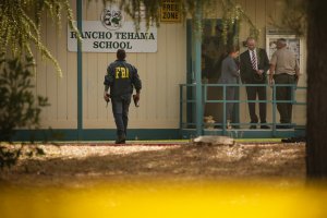 FBI agents are seen behind yellow crime scene tape outside Rancho Tehama Elementary School after a shooting in the morning on November 14, 2017, in Rancho Tehama, California. Witness Brian Rogers – who was across the street when the first shots rang out – said he heard single-fire shots by the school as if someone were taking time to pick targets a shot and the yelp of a dog, and to the south, a man at the municipal airport screaming for help, and more shooting there. (Credit: ELIJAH NOUVELAGE/AFP/Getty Images)