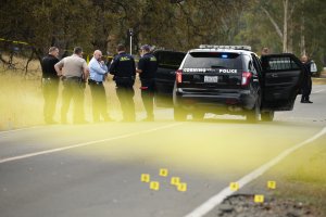 Law enforcement officers and investigators converse near a police vehicle that was involved in a shooting on November 14, 2017, in Rancho Tehama, California. (Credit: Elijah Nouvelage/AFP/Getty Images)