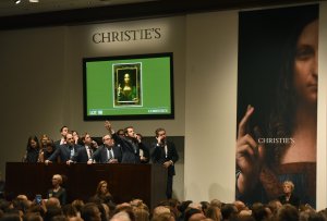 Christie's employees take bids for Leonardo da Vincis "Salvator Mundi" at Christie's New York on November 15, 2017. A 500-year-old work of art depicting Jesus Christ, believed to be the work of Renaissance master Leonardo da Vinci, sold in New York $450.3 million setting a new art auction record, Christie's said. (Credit: Timothy A. Clary/AFP/Getty Images)