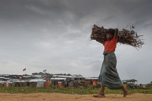 A Rohingya refugee child walks back to his house with a bundle of dry wood at Thankhali refugee camp in Bangladesh on Nov. 17, 2017. (Credit: Munir Uz Zaman / AFP / Getty Images)