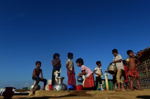 Rohingya refugee children collect drinking water from a tube well at Hakimpara refugee camp in the Bangladeshi district of Ukhia on Nov. 18, 2017. (Credit: Munir Uz Zaman / AFP / Getty Images)