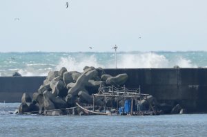 The wreckage of a boat is pictured along a sea wall in the city of Yurihonjo, Akita prefecture on November 24, 2017. (Credit: AFP/Getty Images)