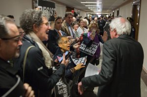 Demonstrators greet Sen. Bernie Sanders on his way to the full committee markup of the FY2018 Reconciliation Legislation on Nov. 28, 2017, in Washington, DC. (Credit: Tasos Katopodis / Getty Images)