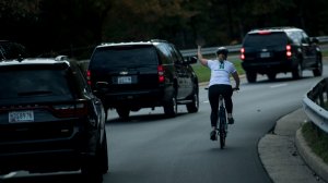 Juli Briskman gestures with her middle finger as a motorcade with U.S. President Donald Trump departs Trump National Golf Course Oct. 28, 2017, in Sterling, Virginia. (Credit: Brendan Smialowski / AFP / Getty Images)