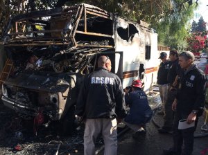 Fire investigators examine the shell of a burned RV after a fatal fire Nov. 20, 2017, in Rancho Park in a photo tweeted by LAFD's Erik Scott.