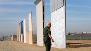 Mario Villarreal, the field office division chief for Customs and Border Protection, walks near the border wall prototypes that were built east of San Ysidro on the border of Mexico, shown here on Nov. 20, 2017. (Credit: K.C. Alfred / San Diego Union-Tribune)
