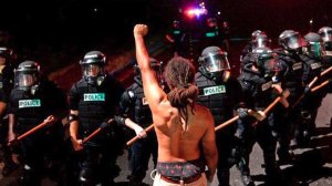 Protester Braxton Winston faces Charlotte-Mecklenburg police officers on Sept. 20, 2016, after a police-involved shooting. Winston won a seat on the Charlotte City Council on Nov. 7, 2017. (Credit: Jeff Siner/The Charlotte Observer/AP via CNN)