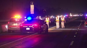 Authorities investigate a fatal crash on the 405 Freeway in Westminster on Dec. 20, 2017. (Credit: KTLA)