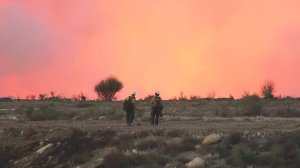 Firefighters face the glow from the Creek Fire on Dec. 6, 2017. (Credit: KTLA)