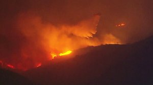 A firefighting helicopter is seen above the Creek Fire on Dec. 5, 2017. (Credit: KTLA)