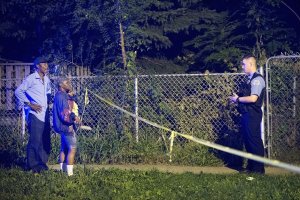 Police officers secure a shooting scene where five people were reported to have been shot, including an 11-month-old infant, on Sept. 28, 2015, in Chicago. (Credit: Scott Olson / Getty Images)
