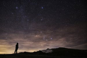 A photographer looks at the sky at night to see the annual Geminid meteor shower on the Elva Hill in northern Italy, Dec. 12, 2015. (Credit: Marco Bertorello / AFP / Getty Images)