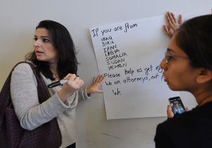 Members of a coalition of immigration lawyers wait for people affected by U.S. President Donald Trump's temporary ban on incoming refugees and travelers from seven Muslim countries, at the Los Angeles International Airport (LAX) in Los Angeles on Jan. 30, 2017. (Credit: Mark Ralston/AFP/Getty Images)