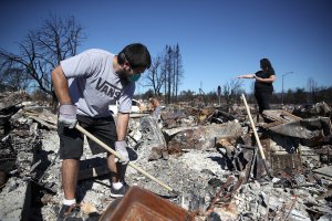 Ben Hernandez Jr., left, sifts through the remains of his Coffey Park home that was destroyed by the Tubbs Fire on Oct. 23, 2017 in Santa Rosa, California. (Credit: Justin Sullivan/Getty Images)
