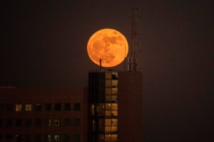 The 'supermoon' rises over a building in the Israeli city of Netanya, on December 3, 2017. (Credit: JACK GUEZ/AFP/Getty Images)