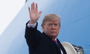 Donald Trump waves from Air Force One prior to departure from Andrews Air Force Base in Maryland on Dec. 4, 2017. (Credit: Saul Loeb/AFP/Getty Images)