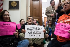 Activists stage a sit-in to protest the GOP tax reform bill outside of office of Rep. Dana Rohrabacher (R-CA) on Dec. 5, 2017. (Credit: Drew Angerer / Getty Images)