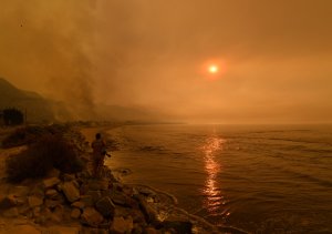 Heavy smoke covers the seaside enclave of Mondos Beach beside the 101 highway as flames reach the coast during the Thomas Fire near Ventura, on Dec. 6, 2017. (Credit: Mark Ralston/AFP/Getty Images)