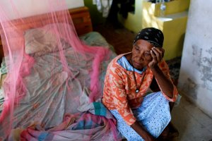 Aurea Cruz, 66, sits on her bed inside her house damaged by Hurricane Maria in Vieques, Puerto Rico, on Nov. 26, 2017. (Credit: Ricardo Arduengo / AFP / Getty Images)