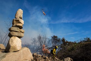 Firefighters cut a fire line near stacked rocks at the Thomas Fire on December 7, 2017 near Fillmore. (Credit: David McNew/Getty Images)