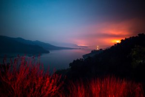 The Thomas Fire burns a hillside behind Lake Casitas near Ventura on Dec. 8, 2017. (Credit: KYLE GRILLOT/AFP/Getty Images)