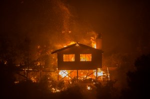 A structure burns in the Lilac Fire in the early morning hours of Dec. 8, 2017, near Bonsall. (Credit: David McNew / Getty Images)