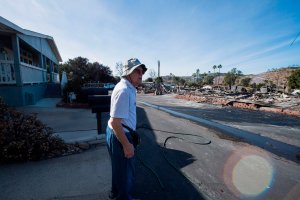 Local resident Pal Paricsy looks over the remains of his neighbors' homes destroyed by the Lilac Fire, Dec. 8, 2017, at a retirement community in Fallbrook, in San Diego County. (Credit: AFP PHOTO / Robyn Beck)