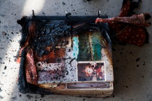 A photo album damaged by fire is see amid the destruction of the Lilac Fire, Dec. 8, 2017, at a retirement community in Fallbrook. (Credit: AFP PHOTO / Robyn Beck)