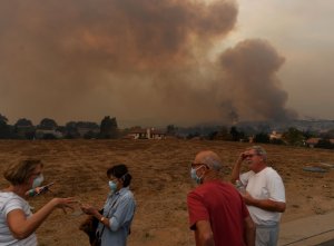 Local residents keep watch while fire and smoke from the Thomas wildfire heads towards their housing estate in Ojai on Dec. 9, 2017. (Credit: Mark Ralston / AFP / Getty Images)