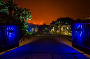 The glow of approaching flames is seen at the gates of an expensive home in Montecito as the Thomas Fire continues to grow on Dec. 12, 2017. (Credit: David McNew / Getty Images)