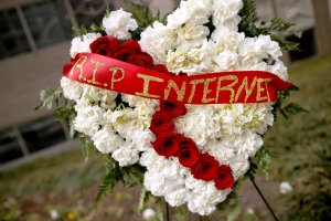 A funeral flower arrangement is set up outside the Federal Communication Commission building during protest against the end of net neutrality rules, Dec. 14, 2017 in Washington, DC. (Credit: Chip Somodevilla / Getty Images)