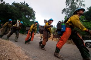 A firefighting hand crew moves into position to put out hotspots in Montecito, California at the Thomas Fire on December 16, 2017. (Credit: ROBYN BECK/AFP/Getty Images)