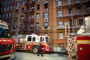 A NYPD officer walks on the scene of an apartment fire in the Bronx borough of New York City on December 29, 2017. (Credit: KENA BETANCUR/AFP/Getty Images)