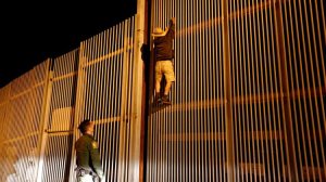 An undated photo shows Border Patrol Agent Eduardo Olmos apprehending a Mexican immigrant trying to cross the U.S.-Mexico border in San Diego. (Gary Coronado / Los Angeles Times)