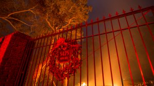 A wreath hangs on the gate of a burned property at the Lilac Fire in the early morning hours of Dec. 8, 2017, near Bonsall in San Diego County. (Credit: David McNew/Getty Images)