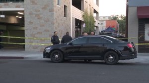 Police investigate the death of a woman who fell from a parking garage in Alhambra on Dec. 14, 2017. (Credit: KTLA)