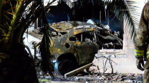 A burned out car is seen as it is being pulled from a Corona home it had crashed into on Dec. 18, 2017. (Credit: LoudLabs)